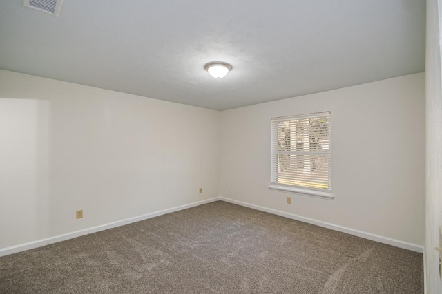 unfurnished room with carpet floors, baseboards, and visible vents