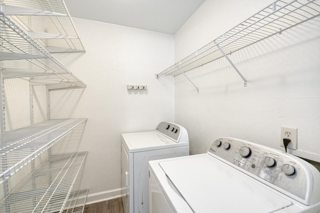 laundry room featuring laundry area, baseboards, separate washer and dryer, and dark wood finished floors