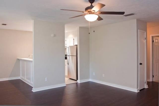 unfurnished room featuring dark wood-type flooring and ceiling fan