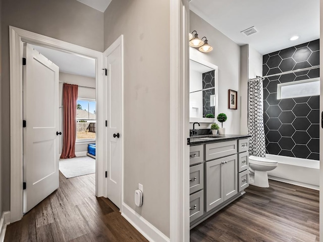 bathroom featuring hardwood / wood-style floors, vanity, toilet, and walk in shower