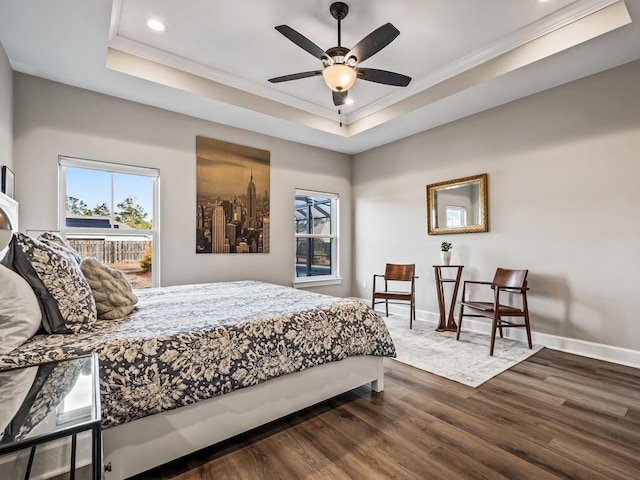 bedroom featuring ornamental molding, a raised ceiling, ceiling fan, and dark wood-type flooring