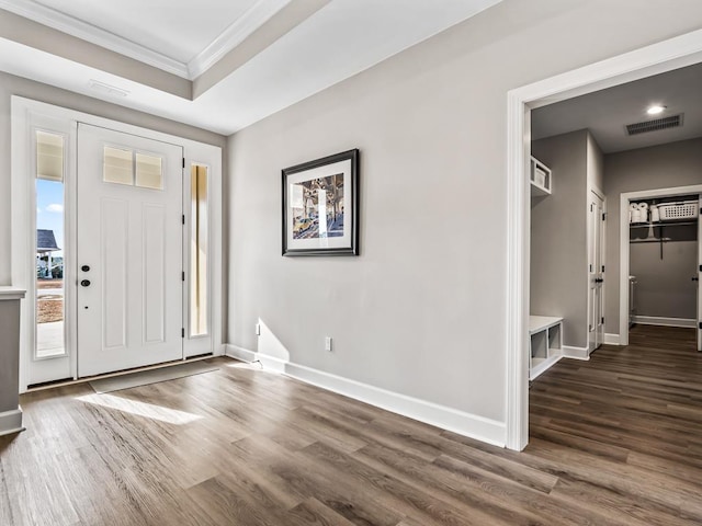 foyer entrance with dark hardwood / wood-style flooring and ornamental molding