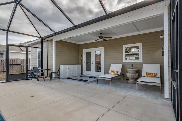 view of patio with ceiling fan, glass enclosure, and french doors