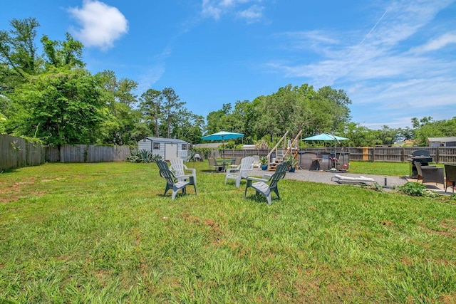 view of yard with a storage shed, an outbuilding, and a patio