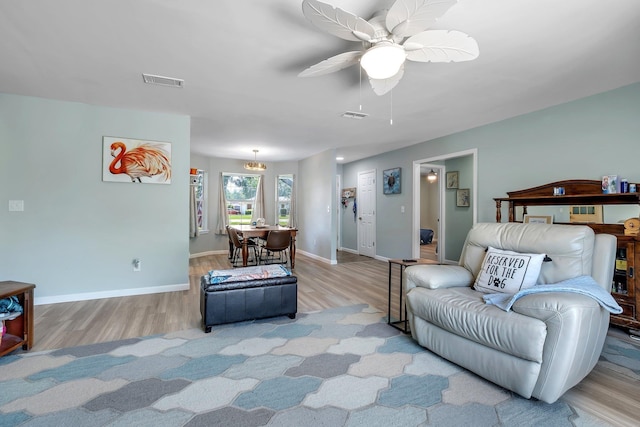 living room featuring wood finished floors, baseboards, and a ceiling fan