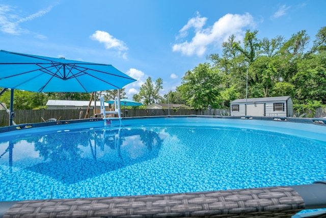 view of swimming pool with a fenced backyard and an outbuilding