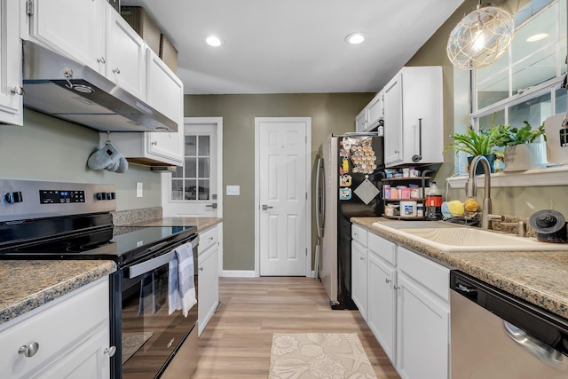 kitchen featuring stainless steel appliances, under cabinet range hood, a sink, light wood finished floors, and white cabinets