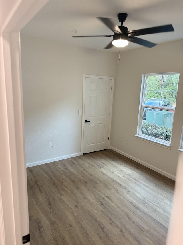 empty room with ceiling fan and light hardwood / wood-style floors