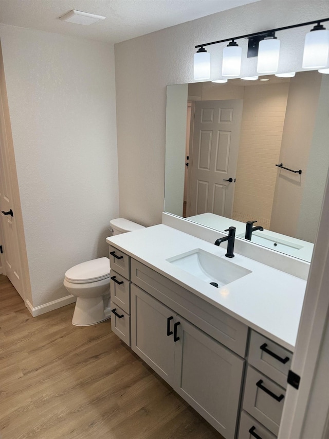 bathroom featuring vanity, hardwood / wood-style flooring, and toilet