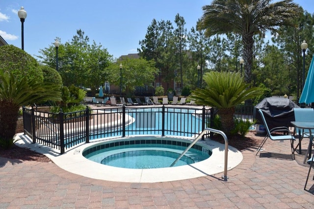 view of swimming pool featuring area for grilling, a community hot tub, and a patio