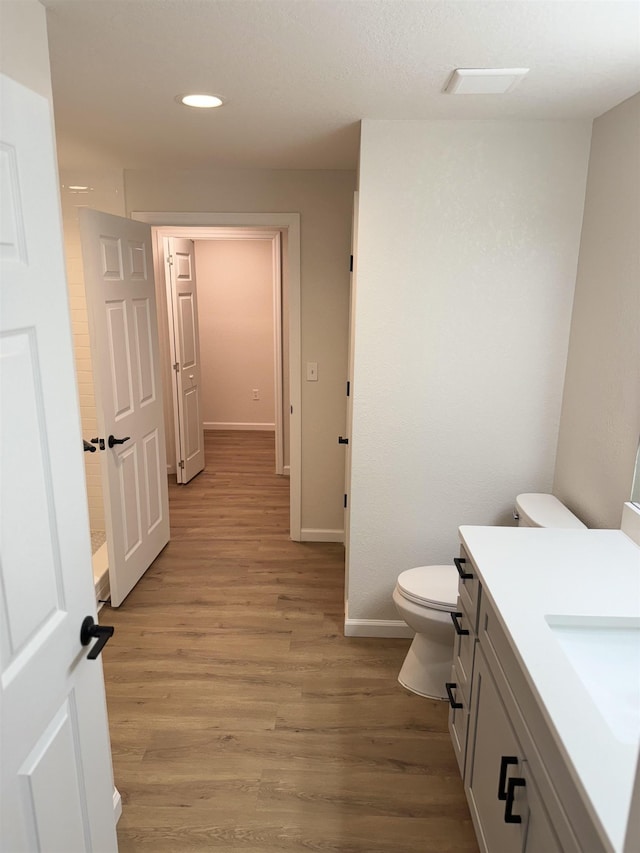 bathroom with vanity, wood-type flooring, and toilet