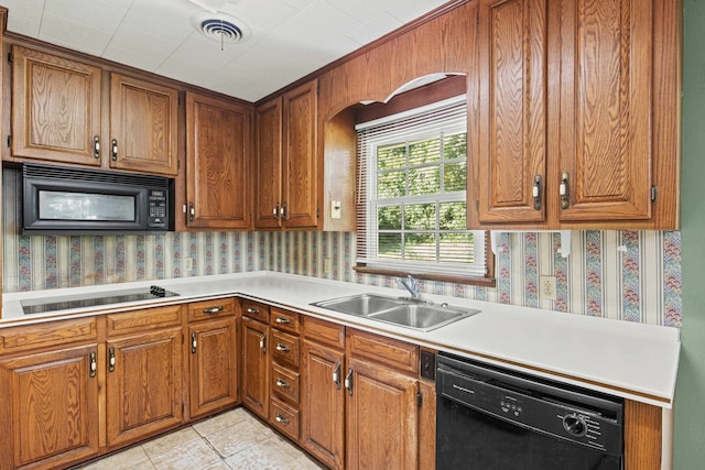 615 N Calhoun St, Quincy, FL 32351 - kitchen with black appliances, wallpapered walls, light countertops, and brown cabinets