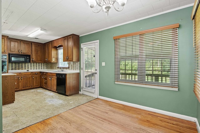 615 N Calhoun St, Quincy, FL 32351 - kitchen with black appliances, light countertops, a chandelier, decorative backsplash, and ornamental molding