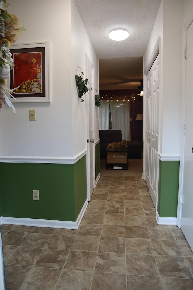 hall featuring a textured ceiling