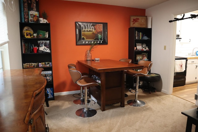 bar featuring white cabinets, light carpet, and black electric range