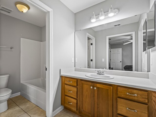 full bathroom featuring washtub / shower combination, tile patterned flooring, vanity, and toilet