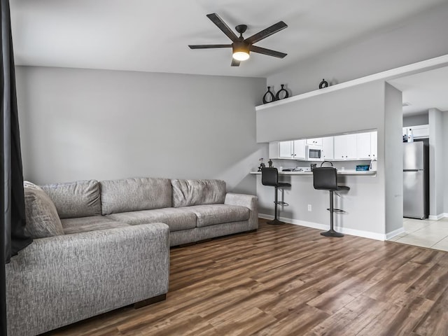 living room with ceiling fan and light hardwood / wood-style floors