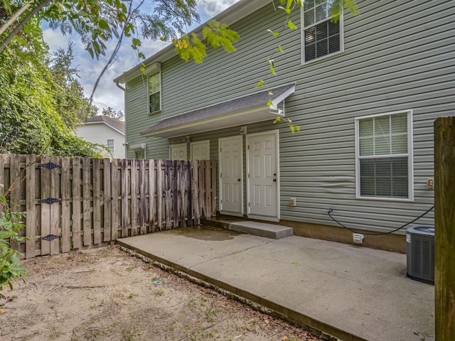 rear view of house with central AC and a patio