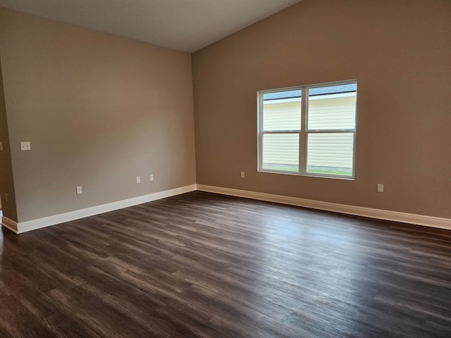 unfurnished room with lofted ceiling and dark wood-type flooring