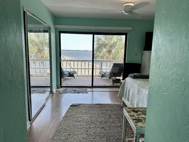2289 Surf Rd Unit B4, Ochlockonee Bay, FL 32346 - bedroom with a textured wall, access to outside, wood finished floors, a water view, and a ceiling fan