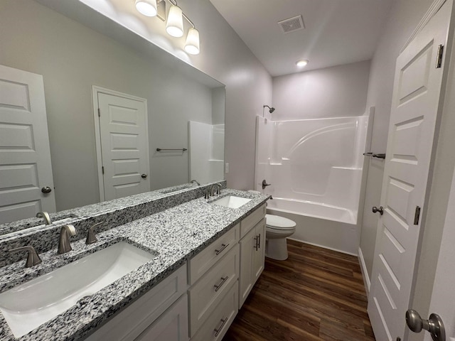 full bathroom with toilet, wood finished floors, a sink, and visible vents