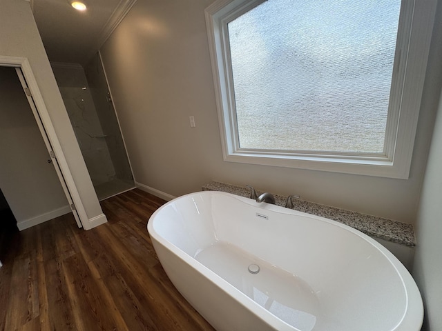 full bathroom with a walk in shower, a soaking tub, wood finished floors, and baseboards