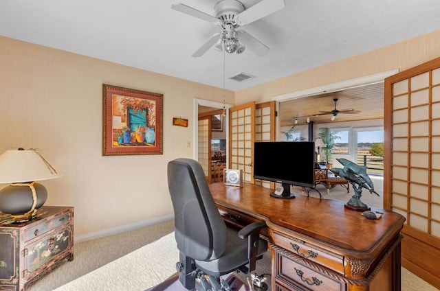 carpeted office space featuring ceiling fan