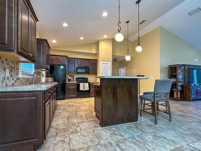 14135 98th St, Live Oak, FL 32060 - kitchen featuring black appliances, vaulted ceiling, dark brown cabinets, a kitchen island, and a sink