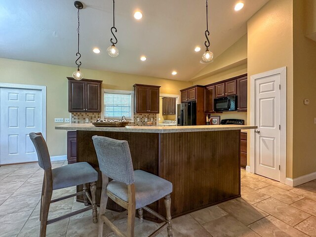 14135 98th St, Live Oak, FL 32060 - kitchen with black appliances, lofted ceiling, dark brown cabinetry, decorative backsplash, and light countertops