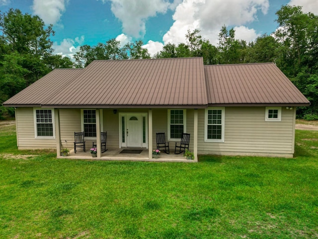 14135 98th St, Live Oak, FL 32060 - back of property with metal roof, a lawn, and covered porch