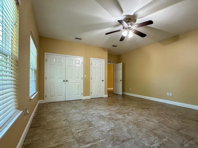 14135 98th St, Live Oak, FL 32060 - unfurnished bedroom featuring baseboards, multiple windows, and stone finish flooring