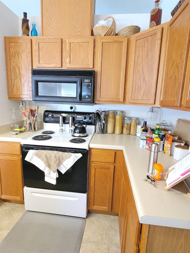 kitchen with electric stove and light tile patterned floors