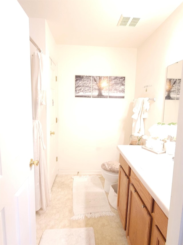 bathroom with toilet, vanity, and tile patterned floors