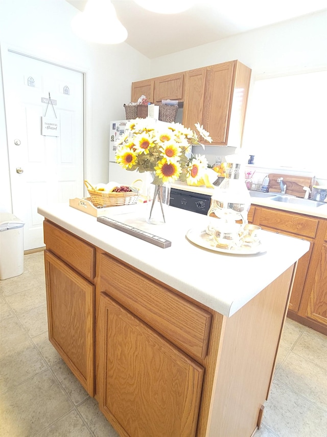 kitchen featuring sink, white refrigerator, and a center island