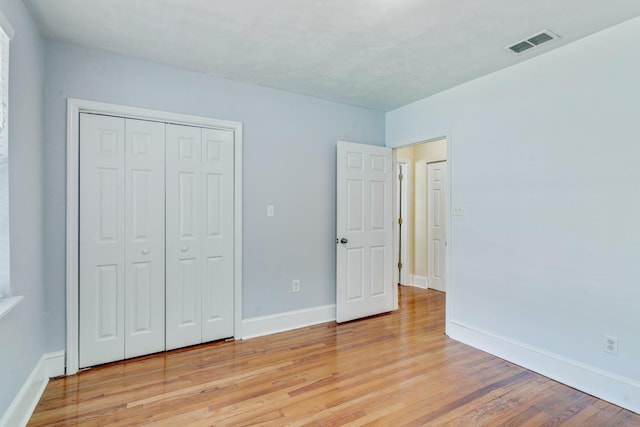 unfurnished bedroom featuring light hardwood / wood-style flooring and a closet