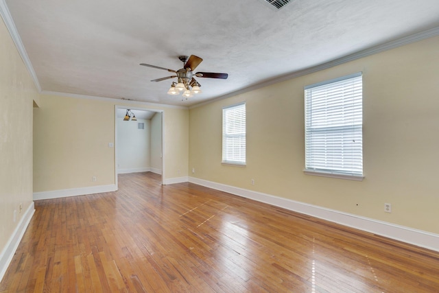 empty room with ceiling fan with notable chandelier, wood-type flooring, and ornamental molding