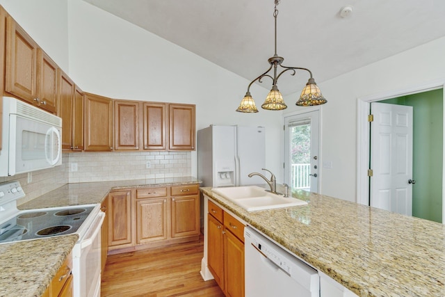 kitchen featuring white appliances, backsplash, sink, light stone countertops, and decorative light fixtures