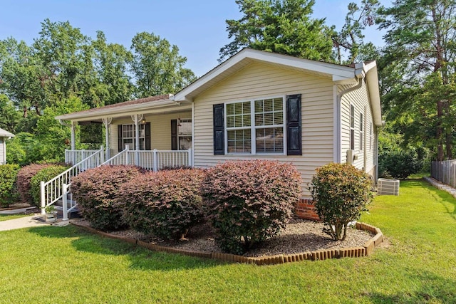 ranch-style home with central air condition unit, a front lawn, and a porch