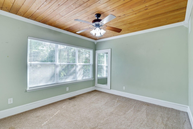 carpeted empty room with ceiling fan, ornamental molding, and wooden ceiling