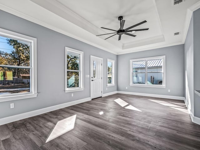 foyer entrance with dark wood-type flooring, ornamental molding, a raised ceiling, and ceiling fan