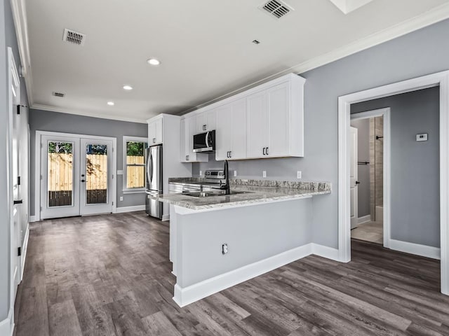 kitchen with white cabinetry, stainless steel appliances, ornamental molding, french doors, and kitchen peninsula