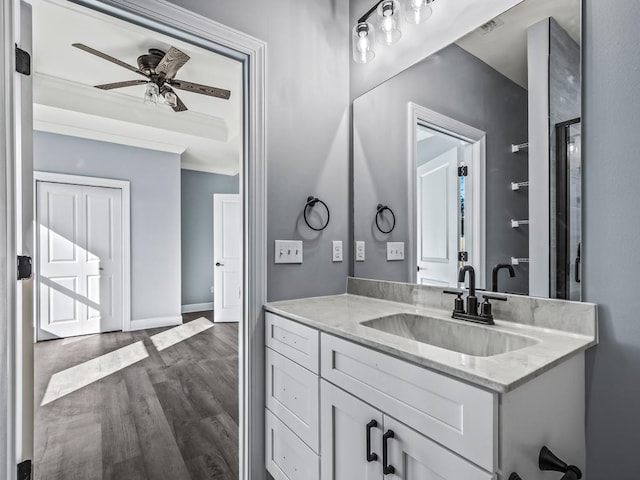 bathroom featuring vanity, crown molding, wood-type flooring, and ceiling fan