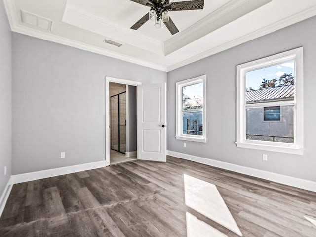 unfurnished bedroom with hardwood / wood-style flooring, ceiling fan, ornamental molding, and a raised ceiling