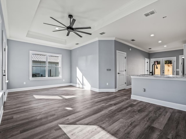 unfurnished living room with dark wood-type flooring, ceiling fan, crown molding, and sink