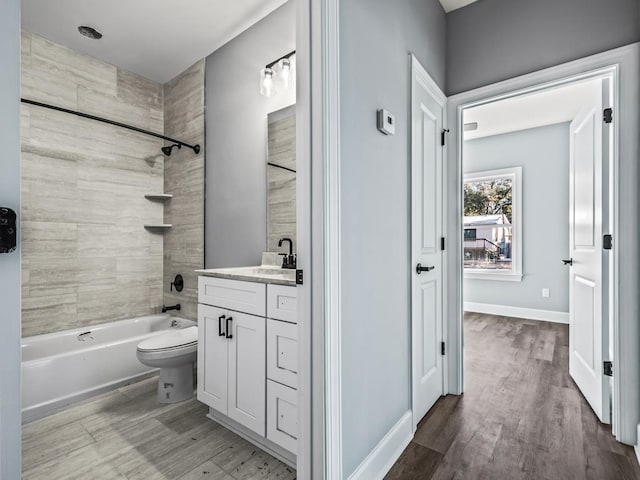 full bathroom with tiled shower / bath combo, vanity, wood-type flooring, and toilet