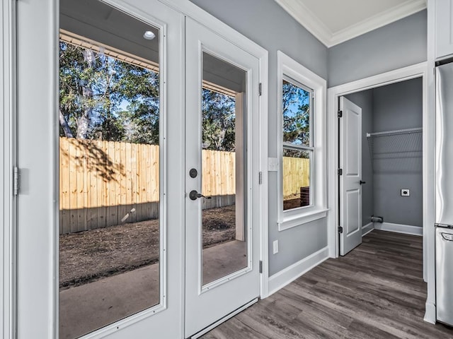 entryway with ornamental molding and dark hardwood / wood-style floors