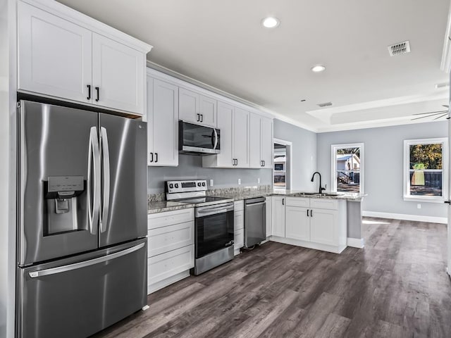 kitchen featuring sink, appliances with stainless steel finishes, dark hardwood / wood-style floors, kitchen peninsula, and white cabinets