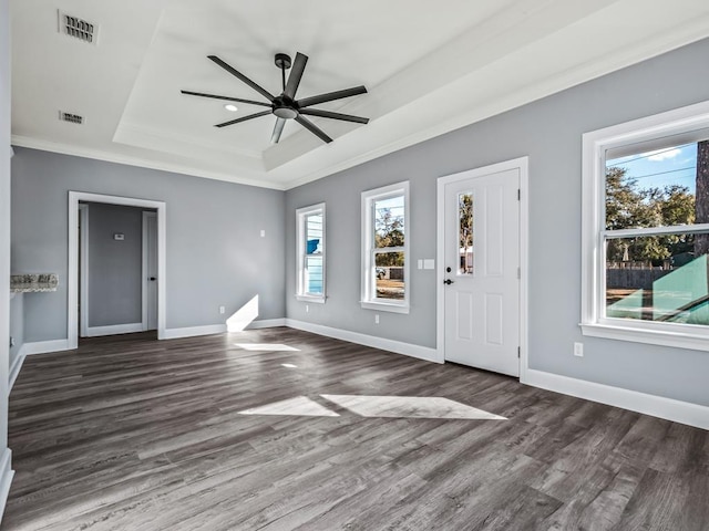 foyer featuring dark hardwood / wood-style floors, ceiling fan, a tray ceiling, and crown molding