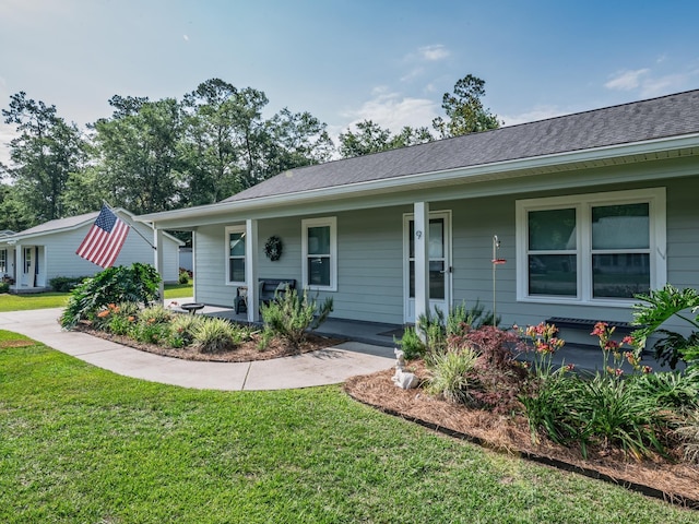 9 Pirates Cove Ln, Saint Marks, FL 32355 - view of front of house featuring a porch, a front yard, and roof with shingles