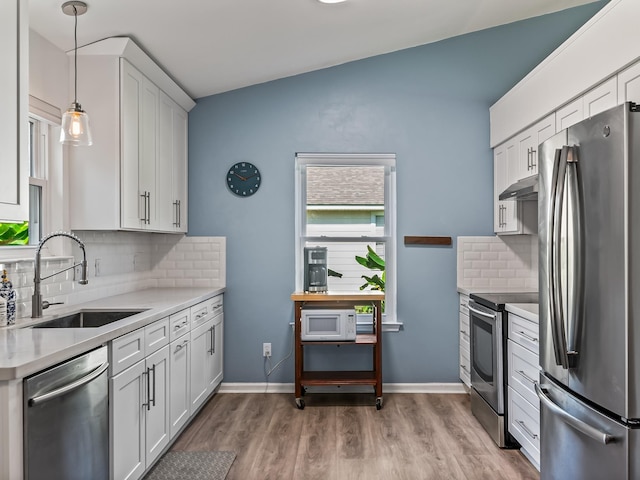 9 Pirates Cove Ln, Saint Marks, FL 32355 - kitchen with appliances with stainless steel finishes, under cabinet range hood, light countertops, backsplash, and light wood-type flooring